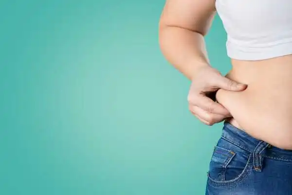Image of woman pinching her love handles to show weight gain Orrell